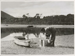 Title
Whitebaiting, Big Bay

Publicity Caption
David stacks tins of whitebait on the beach after rowing down the beautiful Awarua River. 

Photographer
Mr. Bigwood
