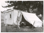 Title
Dr. C. S. Williams - A day on his country rounds.

Publicity Caption
These are the living quarters of Paul Paora, 75 year old "rangitira" of the district. He is building another house under the guidance of Dr. Williams, using concrete bricks made from sand and cement, on his own native property. This tent is typical of many Maori homes visited by the doctor on his daily country run.

Photographer
K.V. Bigwood