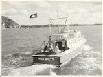 Title
Vice-Regal Party at Russell

Publicity Caption
Miss A. Ashton, Lady-in-waiting to Her Excellency, with Capt. I. Bruce (left), Military Aide, and Lt. A. Campbell Harris, Naval Aide, on the launch "Miss Brett". Miss Ashton caught the 216 lb. Striped Marlin shown on the launch. The flag indicates the catch.

Photographer
Mr. Christensen.