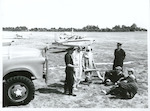 Title:
Walsh Memorial Scout Flying School at Matamata.

Publicity Caption:
Left to Right - Chief Fire Officer, Doug Shawker of Christchurch;  Arthur Tomlinson, Reporoa;  John Funnell, Himitangi; Crash Fireman Malcolm Yates, Wellington; and Peter Simpson, Auckland, learning the use of close proximity suits and equipment.  At the Walsh Memorial Scout Flying School at Matamata.

Photographer:
Mr Nicholson.