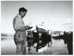 Title:
Government Service - Marine Deparatment

Publicity Caption:
A moment of tranquility for a hard-pressed man.  Mr D. Ireland an engineer surveyed of the Marine Department in Wellington pauses to complete his notes after giving the inter-island steamer express "Maori" a thorough check during its annual survey on the floating dock.  The Marine Department is short of engineers, and those who are on the job have no trouble filling a days work.

Photographer:
D. Nicholson.