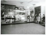 Title:
Evans Bay Intermediate School

Publicity Caption:
Mural in foyer - Wellington artist John Drawbridge was commissioned to do this in 1965. The mural is in symbolic style rather than representation. It takes us on a round trip through Miramar Peninsula. Beginning at bottom right we have Island Bay and hence through the heads and after a deviation to Wellington Airport, through Miramar Cutting to Miramar and Burnham Wharves.  At middle top we are passing through Evans Bay with boat sheds and small craft filling the left and centre of the mural. Finally at bottom centre is a representation of Kilbirnie Green, stronghold of Poneke Rugby Club. To right of the mural is the Monowai ships' bell, presented to the school in 1965 by USS Co. Monowai had a distinguished war record as a armed merchant cruiser and troop carrier. She was employed often on convoy escort duties and in January 1942, had an encounter with a Japanese submarine outside Suva Harbour.

Photographer:
R Silcock