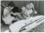Title:
Maoris - Carving 

Publicity Caption:
Master carver John Taiapa teaching two Maori youths carving, Rotorua 

Photographer:
R Anderson