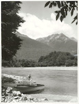 Title:
Fishing - Trout

Publicity Caption:
Peter Donaghy, a fishing guide with the Hollyford Tourist and Travel Co., landing a brown trout caught in the Hollyford River. The Bryneira Range is in the background, Fiordland National Park. Otago

Photographer:
R. Anderson