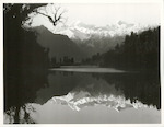 Title:
Westland - Matheson, Lake

Publicity Caption:
Lake Matheson, Mt. Tasman (at left) together with Mt. Cook (at right) mirrored in the reflections of the Lake

Photographer:
M. Berthold