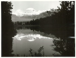 Title:
Westland - Matheson, Lake

Publicity Caption:
Lake Matheson, Mt. Tasman (at left) together with Mt. Cook (at right) mirrored in the reflections of the Lake

Photographer:
M. Berthold