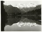 Title:
Westland - Matheson, Lake

Publicity Caption:
Lake Matheson, Mt. Tasman (at left) together with Mt. Cook (at right) mirrored in the reflections of the Lake

Photographer:
M. Berthold