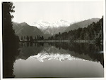 Title:
Westland - Matheson, Lake

Publicity Caption:
Lake Matheson, Mt. Tasman (at left) together with Mt. Cook (at right) mirrored in the reflections of the Lake

Photographer:
M. Berthold