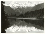 Title:
Westland - Matheson, Lake

Publicity Caption:
Lake Matheson, Mt. Tasman (at left) together with Mt. Cook (at right) mirrored in the reflections of the Lake

Photographer:
M. Berthold