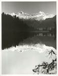 Title:
Westland - Matheson, Lake

Publicity Caption:
Lake Matheson, Mt. Tasman (at left) together with Mt. Cook (at right) mirrored in the reflections of the Lake

Photographer:
M. Berthold