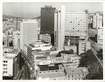 Title:
Wellington City - Buildings

Publicity Caption:
A view from the roof of Challenge House. Lambton Quay is to the left and The Terrace is on the right. Buildings in the centre of the picture are the Wales Building, Williams Centre and James Cook Hotel

Photographer:
T.W. Hann