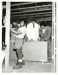 Title:
Schools - Technical

Publicity Caption:
Carpentry instructor Murray Jones shows apprentices, Ioapo Nikolao (left) and George Napa how to hang doors in one of several houses being built by students attending the Manukau Technical Institute

Photographer:
G. Riethmaier