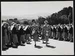 Queen Elizabeth and Plunket Society President Bodkin pass a row of nurses on their tour of the Truby King-Harris (Karitane) Hospital grounds, Dunedin, 27 January 1954